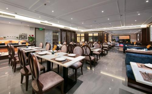 a dining room with tables and chairs in a restaurant at The Q Hotel in Hanoi