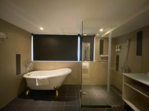 台北的住宿－儷客旅店-台北車站館 ，大型浴室设有浴缸和淋浴。