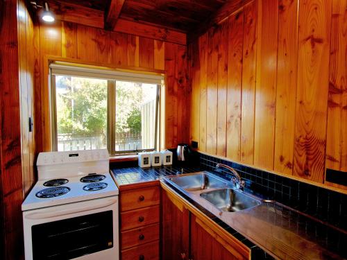 a kitchen with a stove and a sink at Ti Kouka Chalet - Ohakune Holiday Home in Ohakune