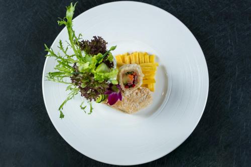 a white plate with food on a table at The Q Hotel in Hanoi