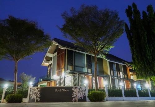 Un edificio con un cartel delante por la noche. en Paklop Resort, en Lopburi
