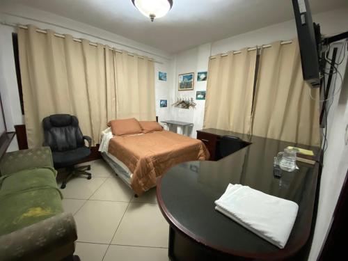 a bedroom with a bed and a desk and a table at Apartamentos Comodos Cerca del Aeropuerto in Guatemala