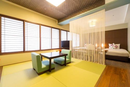 a room with a table and chairs and a bedroom at Hotel Resol Trinity Sapporo in Sapporo