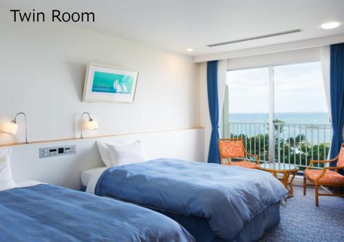 ein Hotelzimmer mit 2 Betten und einem Balkon in der Unterkunft Marine Piazza Okinawa in Motobu