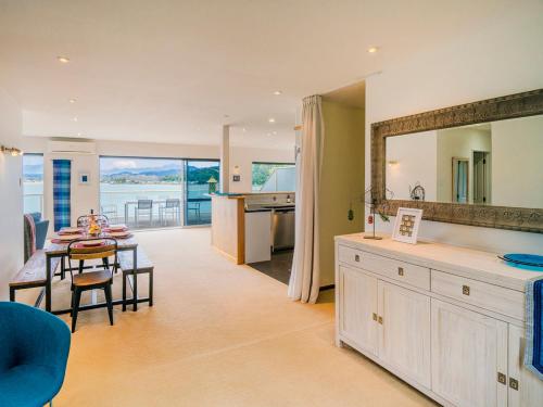 a kitchen and living room with a table and a dining room at Seaview Serenity- Whitianga Holiday Home in Whitianga