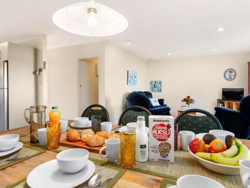 a dining room table with food on top of it at Mokoia Sunrise - Lakefront Ngongotaha Holiday Home in Ngongotaha
