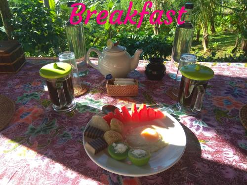 une table avec une assiette de nourriture sur une table dans l'établissement Bali mountain forest cabin, à Penebel