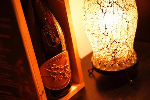 a bottle of wine and a vase next to a bottle of champagne at Hotel Resol Trinity Sapporo in Sapporo