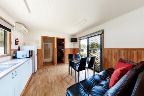 a living room filled with furniture and a kitchen at Torquay Foreshore Caravan Park in Torquay