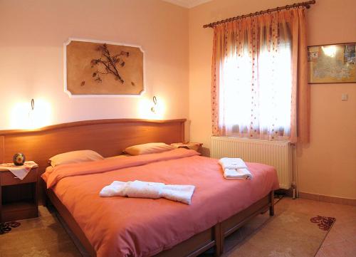 1 dormitorio con 1 cama con 2 toallas en Guesthouse Lina, en Kato Loutraki