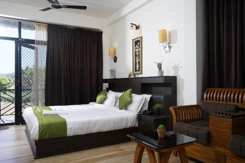 a bedroom with a bed and a living room at Paddyfield Inn in Mananthavady