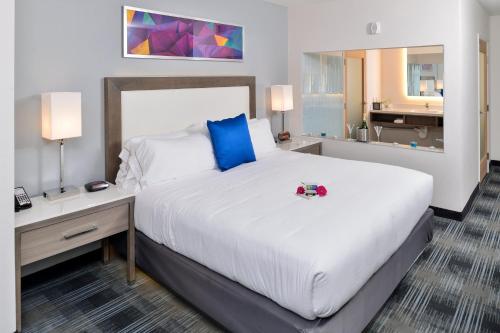 a hotel room with a large bed and a desk at Holiday Inn Express & Suites San Diego - Mission Valley by IHG in San Diego