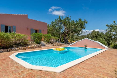 a swimming pool in front of a house at Morro dos Anjos - authentic farmhouse with a view just 3km from Olhao in Olhão