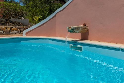 a water fountain in a swimming pool at Morro dos Anjos - authentic farmhouse with a view just 3km from Olhao in Olhão