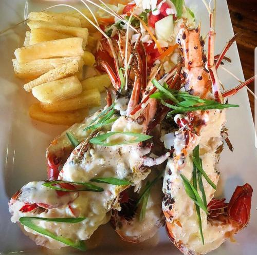 a plate of food with shrimp and french fries at Golden Point Resort in Rakiraki