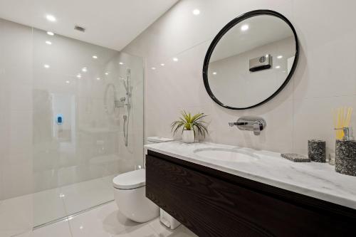 a bathroom with a sink and a toilet and a mirror at Queenstown Lake Views - Downstairs Apartment in Queenstown