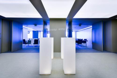a large room with blue walls and white columns at 72 Hotel Sharjah in Sharjah