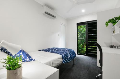 a white room with a bed and a window at MiHaven Shared Living - Martyn St in Cairns