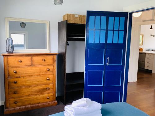 1 dormitorio con puerta azul y vestidor en Uptown City Haven - Christchurch Townhouse, en Christchurch
