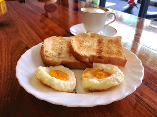 a plate with eggs and toast and a cup of coffee at Urban Hostel Bangkok in Bangkok