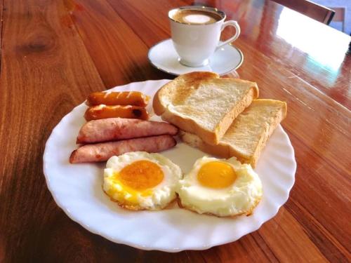 a plate of breakfast food with eggs sausage and toast at Urban Hostel Bangkok in Bangkok