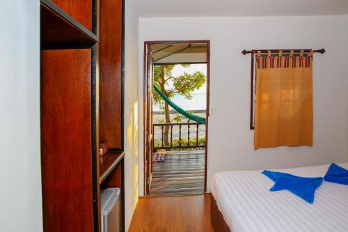 a bedroom with a bed and a door to a balcony at Laemson Resort in Srithanu