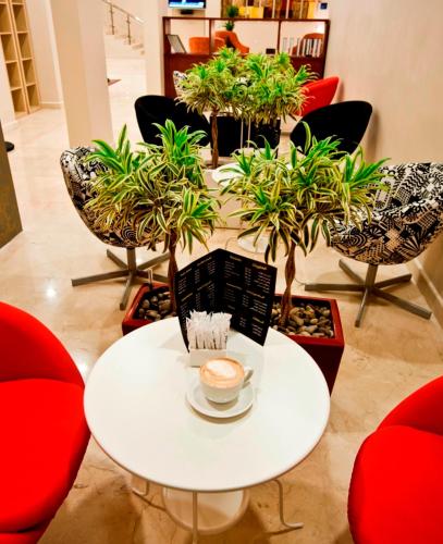a table and chairs with a cup of coffee on it at الأجنحة التنفيذية للشقق المخدومة - اقتصادي in Riyadh