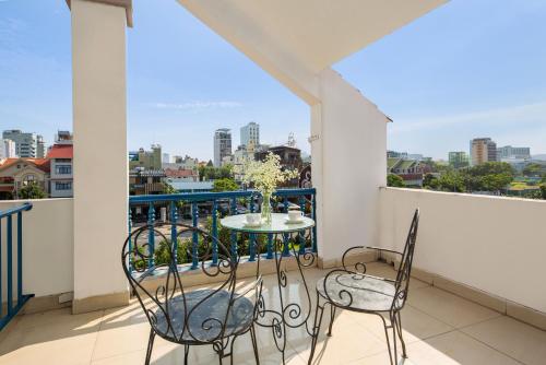 a balcony with a table and chairs and a view of the city at Sofia Boutique Hotel in Danang