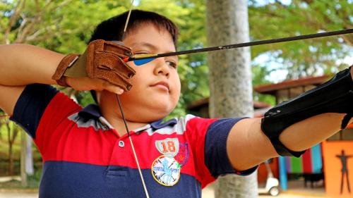 a young boy wearing glasses and a baseball glove at Indra Maya Pool Villas in Lagoi