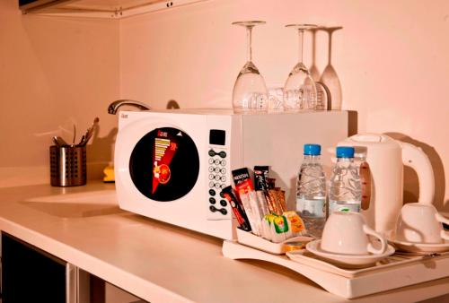 a kitchen counter with a microwave with a sticker on it at Executive Suites in Riyadh