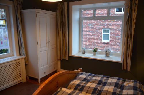 a bedroom with a bed and two windows at Bickbargen in Halstenbek