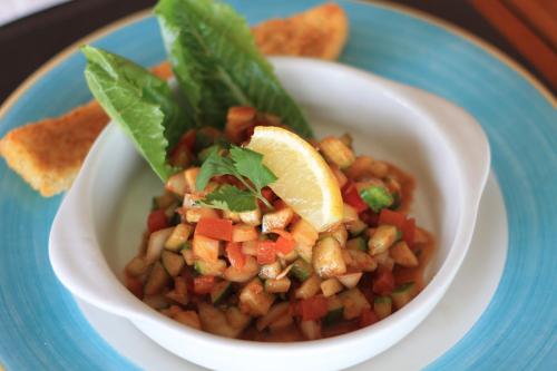 a bowl of salsa with lettuce and vegetables and chips at Indra Maya Pool Villas in Lagoi