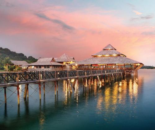 a resort on the water at dusk at Indra Maya Pool Villas in Lagoi