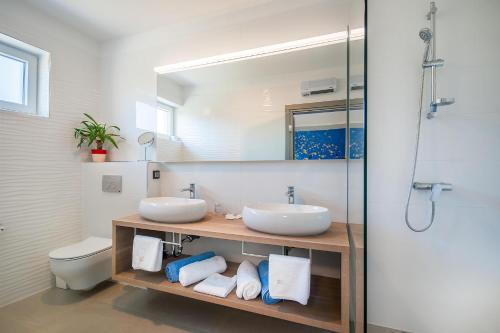 a bathroom with two sinks and a mirror at San Mar Lopar in Lopar