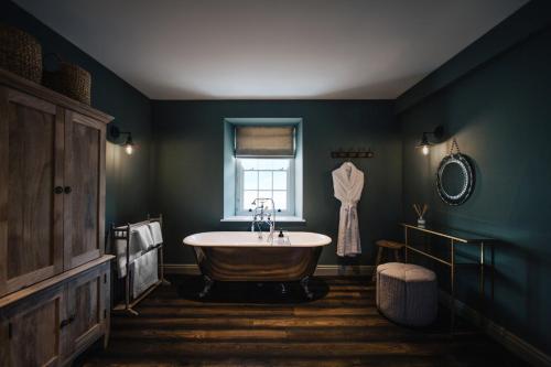 a bathroom with a bath tub and a window at Blonde Hedgehog in Alderney