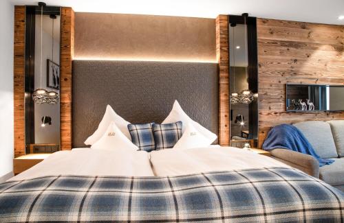 a hotel room with a bed, chair, and nightstand at Hotel Sonne Ischgl in Ischgl