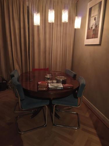 a dining room table with two chairs and a table with books at Charming Family Home in Delft
