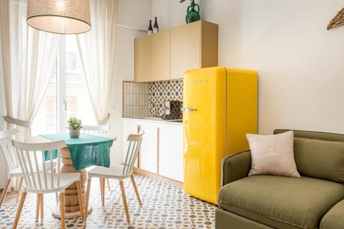 a living room with a couch and a yellow refrigerator at Dimora Labbate in Polignano a Mare