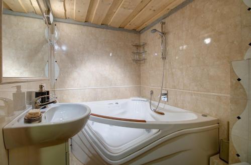 a bathroom with a sink and a bath tub at Domki Odpocywadło in Witów