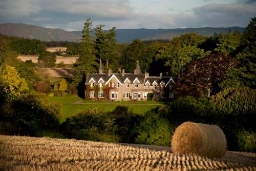 a large house in the middle of a field at Ballathie House Hotel in Perth