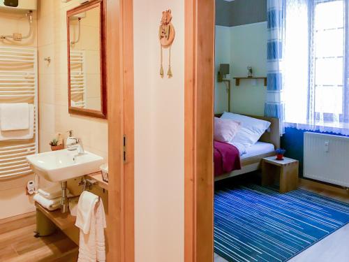 mała łazienka z umywalką i łóżkiem w obiekcie Golden Wood Apartments w Pilznie