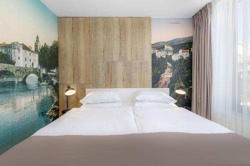 um quarto com uma cama branca e uma grande janela em Boutique Hotel Esplanade em Crikvenica