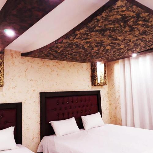 a bedroom with two beds with white sheets at WADI RUM STAR WARS CAMP in Wadi Rum