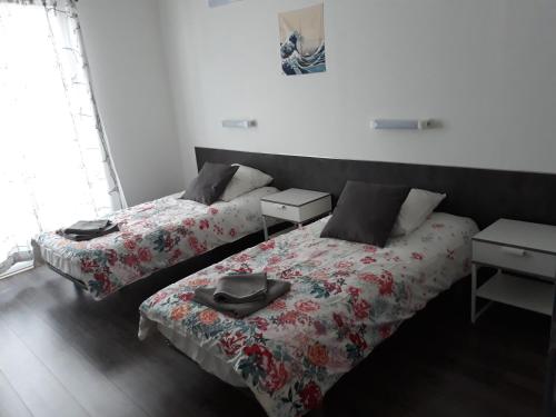 two beds in a room with a white bedspread at Gite Izaxulo in Saint-Jean-Pied-de-Port