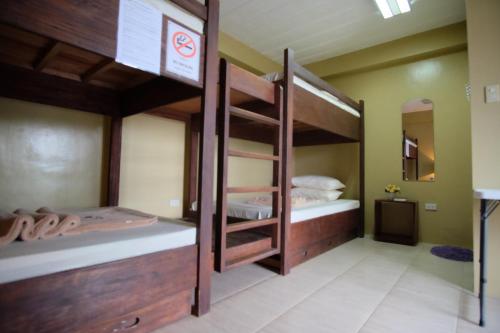 two bunk beds in a room with a mirror at Pacific Waves Inn (Annex) in Baler