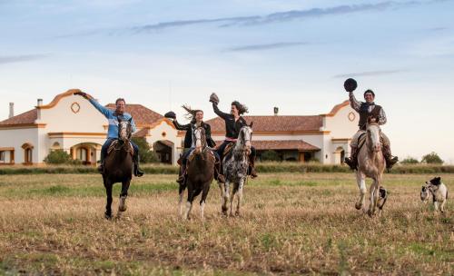 a group of people riding horses in a field at El Colibri in Santa Catalina