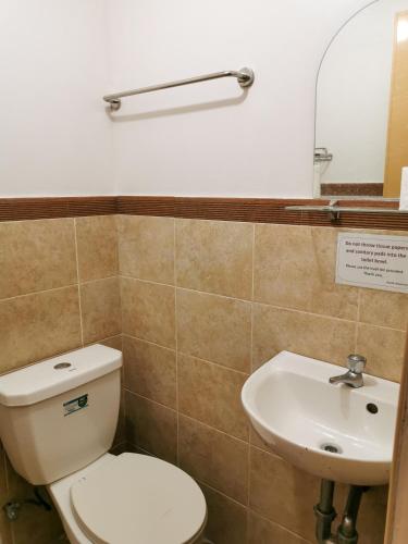 a bathroom with a toilet and a sink at Pacific Waves Inn (Annex) in Baler
