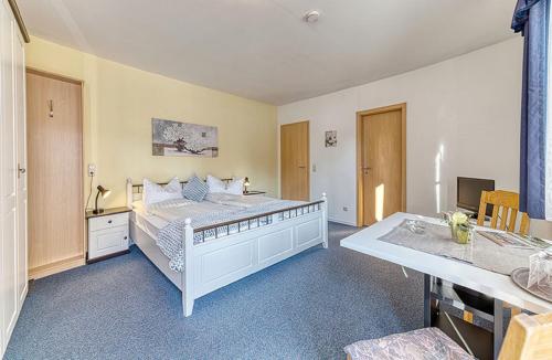 a bedroom with a large white bed and a desk at Appart-Hotel Wildererstuben in Bodenmais
