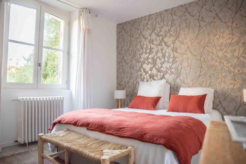 a bedroom with a large bed with red pillows at VILLA LES OMBREES in Arcachon