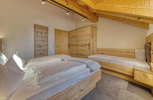 two beds in a room with wooden walls and ceilings at Appart-Hotel Wildererstuben in Bodenmais
